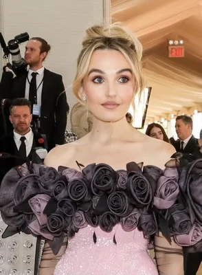 Chloe Fineman lors d'un événement, vêtue d'une robe rose à sequins et ornements floraux.