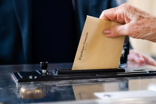 Un électeur dépose son bulletin dans l'urne transparente lors d'un scrutin.