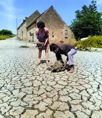 Été 1976 : deux personnes observent la terre craquelée lors de la sécheresse historique.