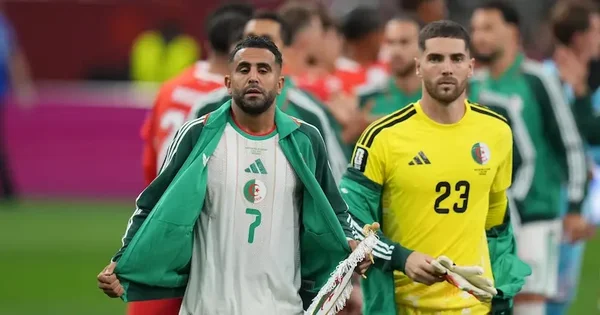 Joueurs de football algériens sur le terrain après l'élimination de l'Algérie de la Coupe du Monde.