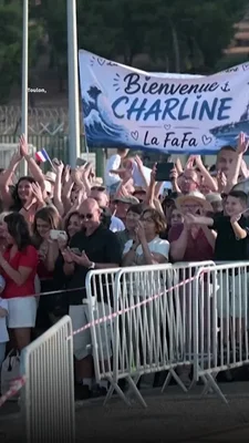 Des proches derrière les barrières, agitant des pancartes et applaudissant le retour des marins du Charles de Gaulle.