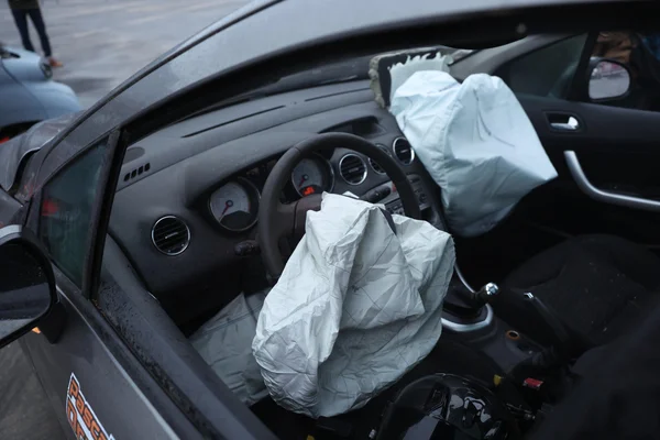 Airbags Takata déployés à l'intérieur d'un véhicule, illustrant le danger potentiel de ces équipements défectueux.