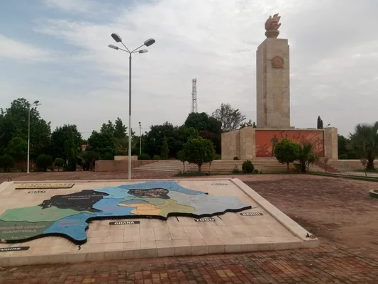La Place de la Nation à Ouagadougou, avec son bas-relief représentant la carte du Burkina Faso et le monument de la flamme en arrière-plan.