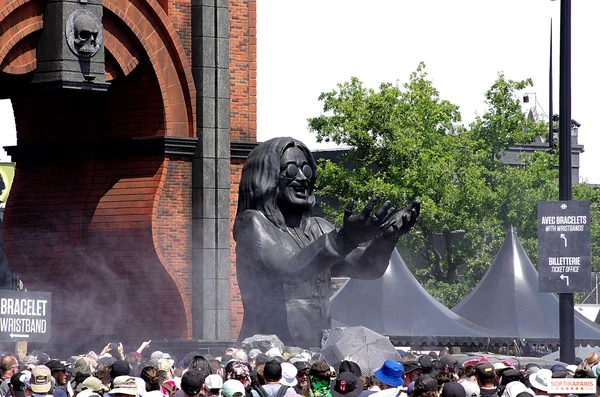 Une imposante statue noire devant une arche en brique au Hellfest 2026, entourée de festivaliers.