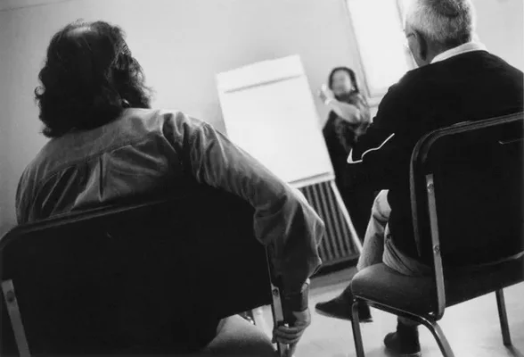 Séance de prise en charge : deux participants vus de dos lors d'un entretien thérapeutique.