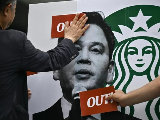 Affiche controversée de Starbucks : portrait d'homme et logo, avec carte 'OUT!'.