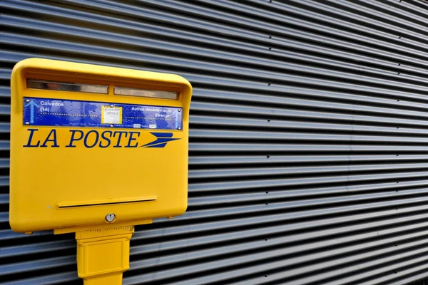 Boîte aux lettres jaune avec consignes de tri, alors que leur nombre diminue.