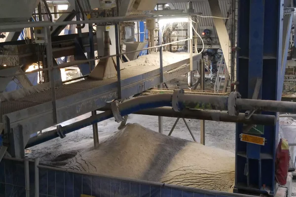 Convoyeur transportant des cendres toxiques dans une usine de traitement.