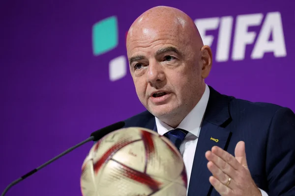 Gianni Infantino, président de la FIFA, lors d'une conférence de presse avec un ballon de football au premier plan.