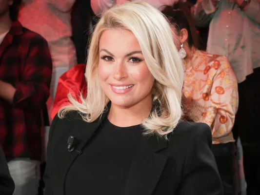 Carla Moreau, star de téléréalité, souriant dans un cadre intérieur.