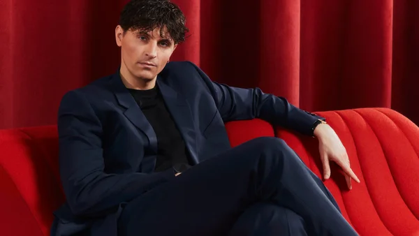 Raphaël Quenard interviewé par Vanity Fair, installé sur un canapé rouge.