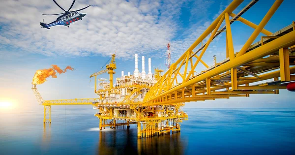Plateforme pétrolière et gazière offshore avec torchère en fonctionnement, illustrant les émissions de méthane de l'industrie.