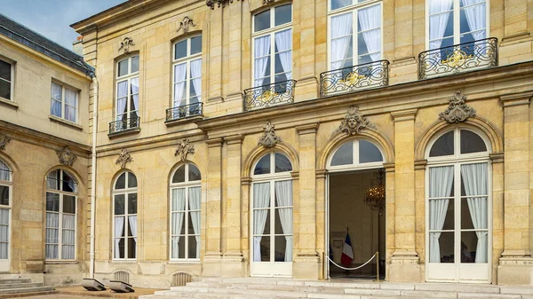 Entrée d'un ministère parisien avec drapeau français et cordons, symbole des bâtiments publics concernés par la future foncière de l'État.
