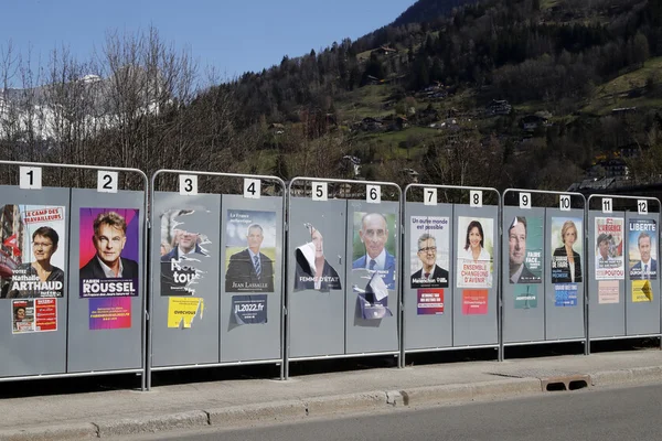 Affiches de candidats à l'élection présidentielle sur un panneau électoral en bord de route.