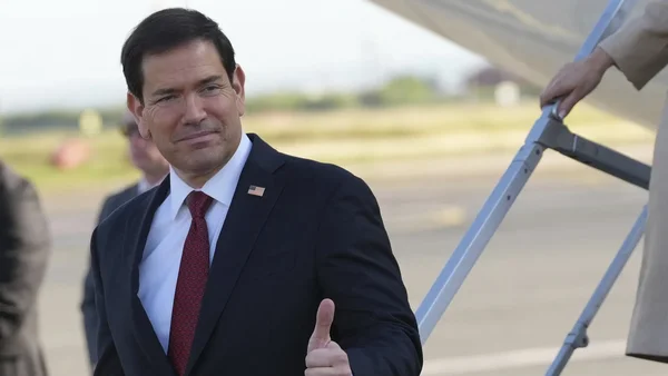 Le secrétaire d'État américain Marco Rubio donnant un pouce levé sur un tarmac d'aéroport.