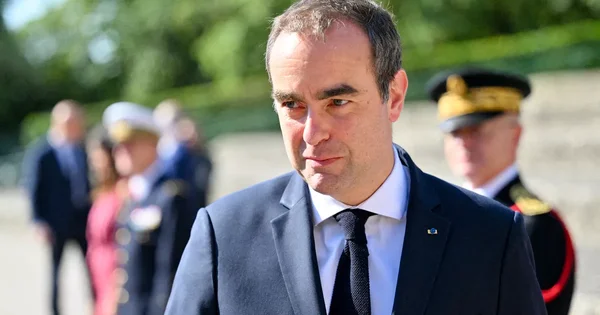 Sébastien Lecornu lors d'un déplacement officiel, entouré de militaires.