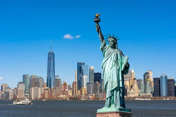 La statue de la Liberté au premier plan, avec la skyline de Lower Manhattan en arrière-plan.