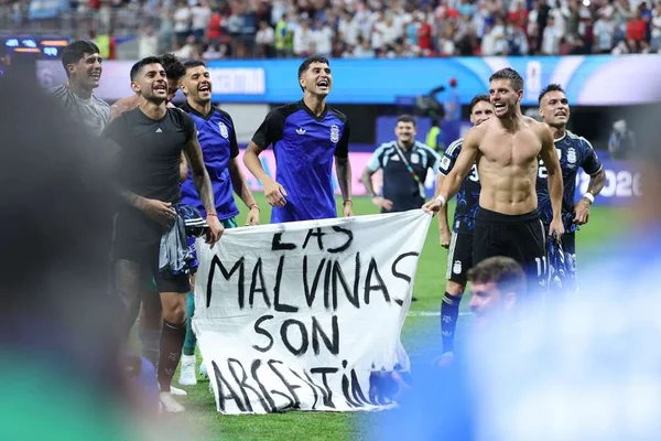 Les joueurs argentins fêtent leur victoire contre l'Angleterre en brandissant une banderole « Les Malouines sont argentines ».