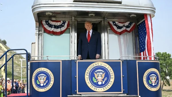 Donald Trump sur la plateforme d'un train décoré aux couleurs américaines, avec le sceau présidentiel.