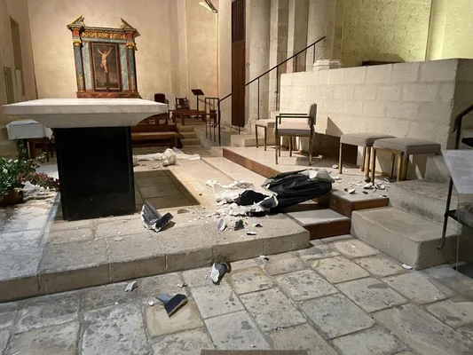 Débris dans le chœur d'une église après un acte de vandalisme, le tabernacle resté intact.