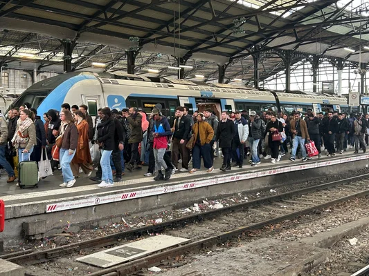 Voyageurs sur le quai de la ligne J, symbole de l'attente prolongée.
