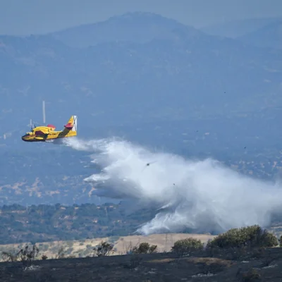 Un avion bombardier d'eau largue du retardateur de feu sur l'incendie près de Madrid.