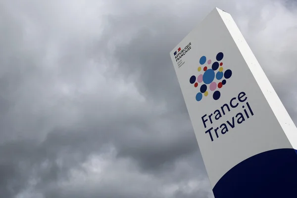 Panneau France Travail sous un ciel nuageux.