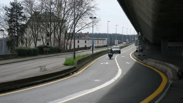 Circulation sur une route courbe sous un viaduc à Saint-Cloud, illustrant les conditions de trafic.