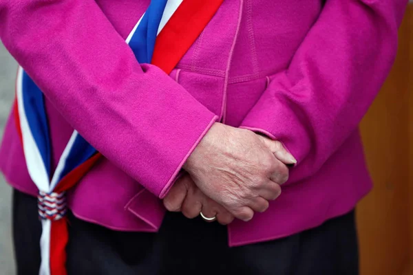 Symbole de la protection des élus : une écharpe tricolore sur une veste rose.