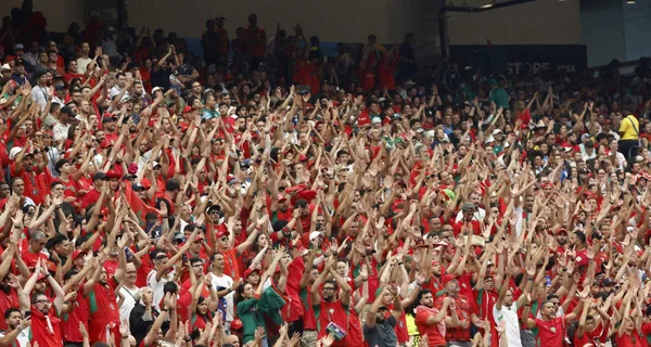 Supporters marocains en rouge remplissant les tribunes d'un stade pendant un match de la Coupe du monde 2022.
