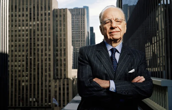 Rupert Murdoch sur un balcon surplombant une ville.