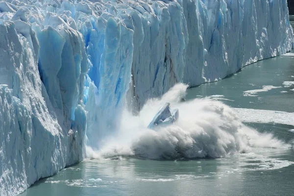 Vêlage d'un bloc de glace d'une paroi glaciaire en Antarctique, montrant la fonte active.