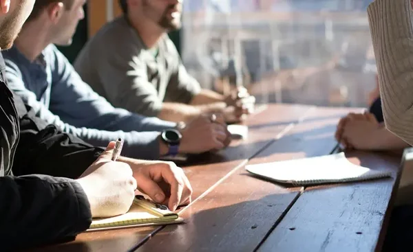 Participants à une réunion prenant des notes dans un atelier en Italie