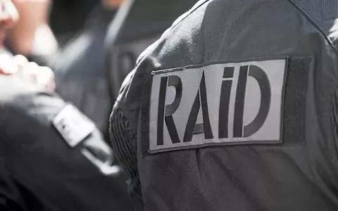 Écusson 'RAID' sur l'épaule d'un agent en opération.