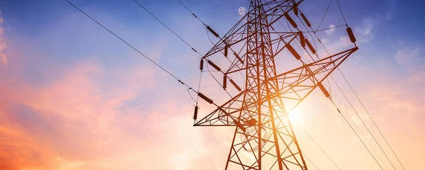 Pylône électrique à haute tension au coucher du soleil, illustrant le réseau de transport d'électricité.