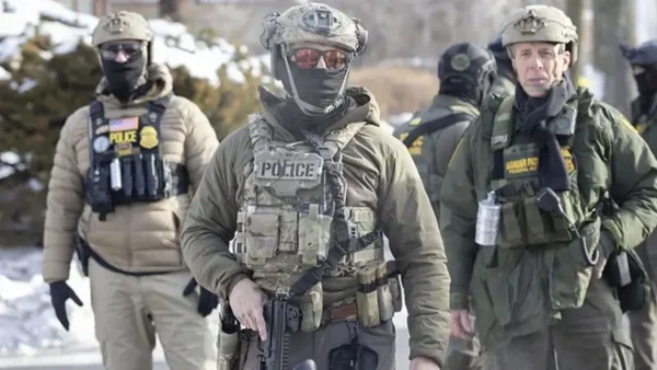 Agents des forces de l'ordre en tenue tactique lors d'une intervention en extérieur sous la neige.