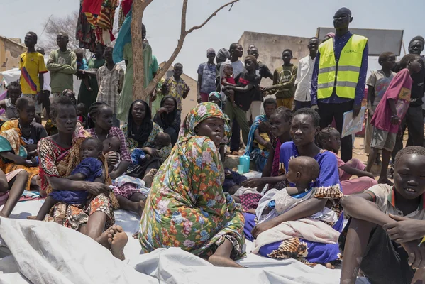 Distribution d'aide humanitaire dans un camp de déplacés au Soudan du Sud, avec un travailleur de l'ONG GOAL.