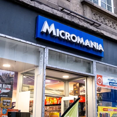 Devanture d'un Micromania avec enseigne bleue et vitrines garnies.