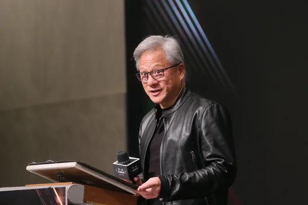 Jensen Huang au pupitre lors de la cérémonie des premiers prix K.T. Li à Taïwan, arborant son célèbre blouson de cuir noir.