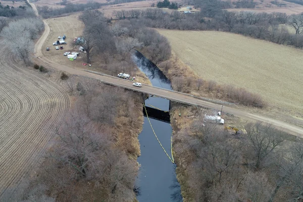 Vue aérienne du site de la fuite de l'oléoduc Keystone au Kansas, avec des barrières de confinement et des véhicules d'urgence.