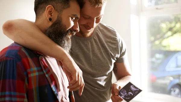 Un couple regardant une échographie, symbole de la parentalité liée à la GPA.