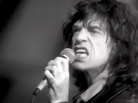 Mick Jagger en concert, capturé dans un moment d'intensité vocale.