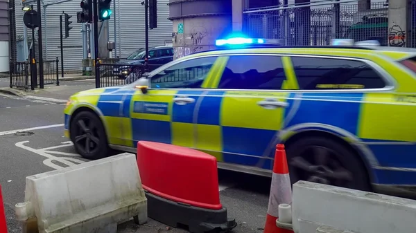 Voiture de police britannique en intervention dans une rue de ville.
