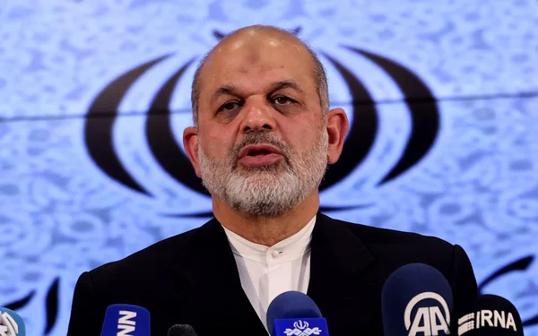 Ahmad Vahidi s'adressant à la presse avec l'emblème de l'Iran en arrière-plan.