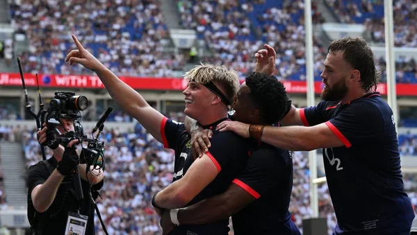 Joueurs anglais célébrant une action sur le terrain.