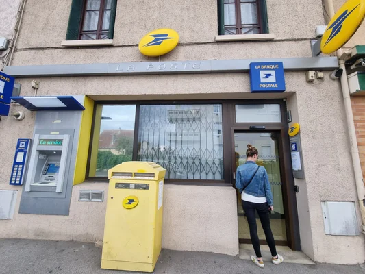 Bureau de poste La Poste avec boîte aux lettres et distributeur, femme entrant.