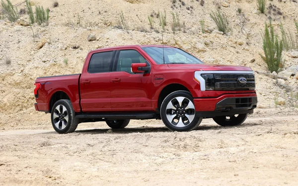 Ford F-150 Lightning rouge dans un environnement désertique.