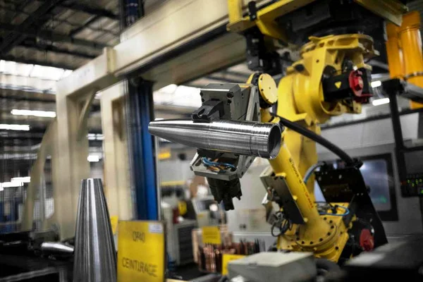 Bras robotisé dans une usine de production de munitions d'artillerie, similaire aux installations de KNDS France.