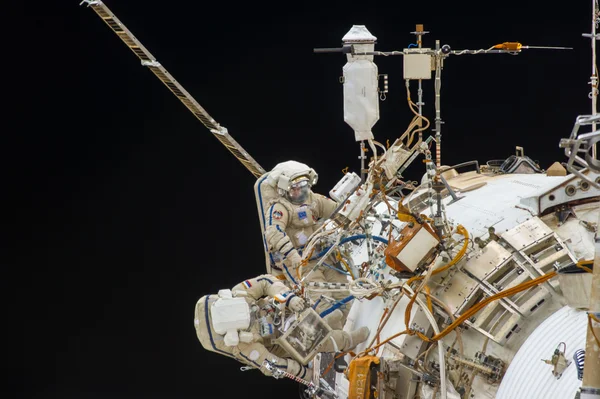 Les cosmonautes Oleg Kotov et Sergueï Riazanski en sortie extravéhiculaire autour de l'ISS.