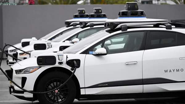 Robotaxis Waymo en recharge dans une station extérieure.